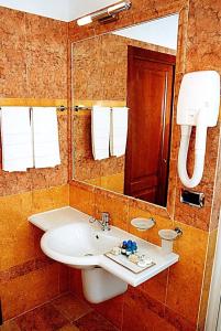 a bathroom with two sinks and a mirror at Hotel Antico Masetto in Lamporecchio