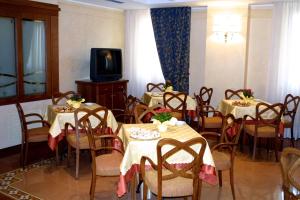 a dining room with tables and chairs and a tv at Hotel Antico Masetto in Lamporecchio