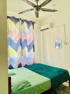 una camera con letto e ventilatore a soffitto di Sis Homestay Wakaf Che Yeh, Kota Bharu a Kota Bharu