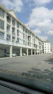 um grande edifício branco com carros estacionados num parque de estacionamento em Sis Homestay Wakaf Che Yeh, Kota Bharu em Kota Bharu