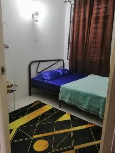 um pequeno quarto com uma cama e um tapete em Sis Homestay Wakaf Che Yeh, Kota Bharu em Kota Bharu
