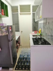 uma cozinha com um fogão e um frigorífico branco em Sis Homestay Wakaf Che Yeh, Kota Bharu em Kota Bharu