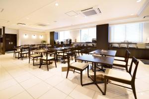 - une salle à manger avec des tables, des chaises et des fenêtres dans l'établissement Sunrise Inn Iwaki, à Iwaki