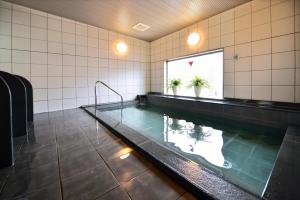 a swimming pool in a building with a pool at Sunrise Inn Iwaki in Iwaki