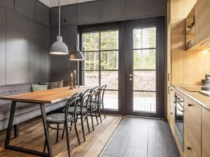 a kitchen with a wooden table and chairs at Holiday home SÄLEN II in Stöten