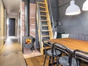 een kamer met een tafel en stoelen en een open haard bij Holiday home SÄLEN II in Stöten