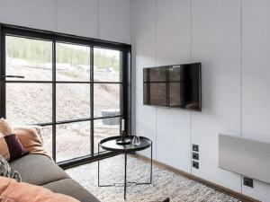 a living room with a couch and a tv on a wall at Holiday home SÄLEN II in Stöten