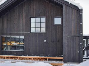 um celeiro de madeira com duas janelas e neve em Holiday home SÄLEN em Stöten