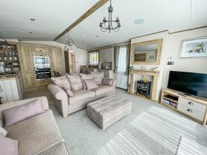 a living room with two couches and a tv at Modern Caravan With Large Decking Area And Wifi, Ref 60057ch in Saxmundham