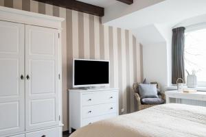 a bedroom with a bed and a television on a dresser at Lodge am Meer in Glücksburg