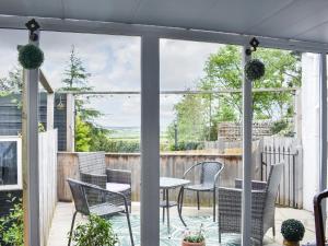 a screened in porch with a table and chairs at Primrose Cottage in Elgin