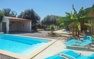 una piscina con sedie blu accanto a una casa di Cozy Home In Salles D'aude With Wifi a Salles-d'Aude
