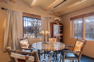 een eetkamer met een tafel, stoelen en ramen bij Casita Mariposa in Santa Fe