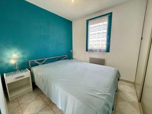 - une chambre avec un lit et un mur bleu dans l'établissement Appartement Saint-Cyprien, 2 pièces, 4 personnes - FR-1-225D-182, à Saint-Cyprien