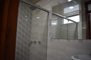 Dorado Plaza في زيباكويرا: حمام مع دش مع مرآة ومغسلة