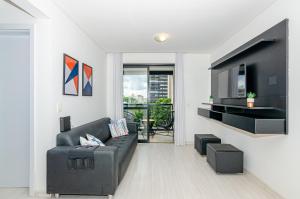 uma sala de estar com um sofá e uma televisão de ecrã plano em Dois quartos, lindo, garagem, Condomínio Clube Sky em Curitiba