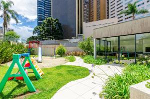 um parque infantil com um escorrega em frente a um edifício em Dois quartos, lindo, garagem, Condomínio Clube Sky em Curitiba