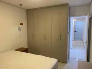 a bedroom with a bed and a large closet at Apto frente praia Gonzaguinha in São Vicente