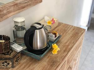 uma chaleira de chá sobre um balcão com flores sobre ele em The Nau Home em Nusa Lembongan