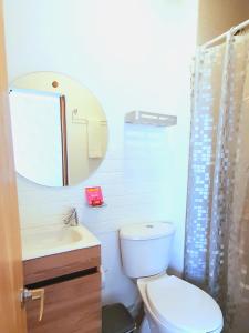 een badkamer met een toilet, een wastafel en een spiegel bij Cómodo apartamento cerca al mar. in Cartagena