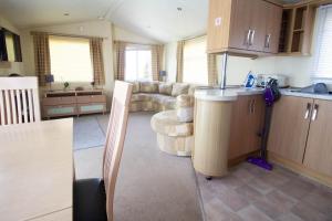 una cucina e un soggiorno con divano di Lovely 6 Berth Caravan With Decking At Sunnydale Holiday Park Ref 35130sd a Louth