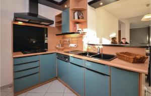 a kitchen with blue cabinets and a sink at Gorgeous Home In Milhaud With Swimming Pool in Milhaud