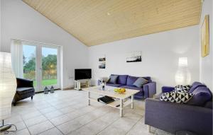 ein Wohnzimmer mit einem lila Sofa und einem Tisch in der Unterkunft Cozy Home In Bog By With Sauna in Bogø By