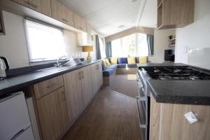 a kitchen with a sink and a stove top oven at Caravan With Decking Within Walking Distance To Hunstanton Beach Ref 23054s in Hunstanton