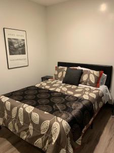 a bed with a black and white comforter and pillows at Hotel Gigi in San Diego