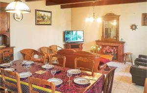 a dining room with a table and chairs and a television at Stunning Home In Le Cloitre S Thegonnec With 4 Bedrooms in Le Cloître-Saint-Thégonnec