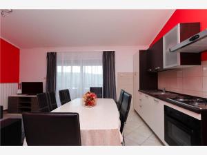 eine Küche mit einem Tisch und Stühlen im Zimmer in der Unterkunft Apartmani 'Mirijana Gabrić' A3 in Lopar