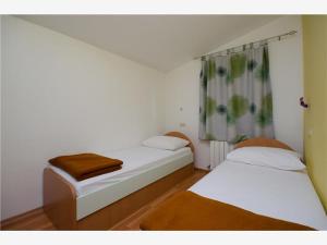 Zimmer mit 2 Betten und einem Fenster in der Unterkunft Apartmani 'Mirijana Gabrić' A3 in Lopar