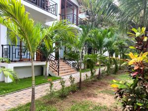 a row of palm trees in front of a building at Gatetrees resort in Jaffna