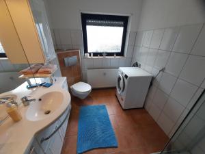 a bathroom with a sink and a washing machine at Fewo klein aber fein 