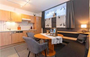 eine Küche mit einem Tisch und einem großen Bildschirm in der Unterkunft Cozy Apartment In Viehhofen With Ethernet Internet in Viehhofen