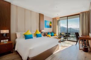 a bedroom with a large bed and a living room at Homie Panorama Beachfront Residences Nha Trang in Nha Trang