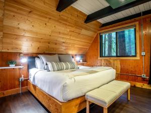 a bedroom in a log cabin with a bed and a window at Treetop Hideaway, Sleeps 2 in Glacier