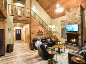 a living room with couches and a fireplace at Cottonwood Cabin in Glacier