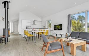 エーベルトフトにあるBeautiful Home In Ebeltoft With 3 Bedrooms And Wifiのキッチン、リビングルーム(テーブル、黄色い椅子付)