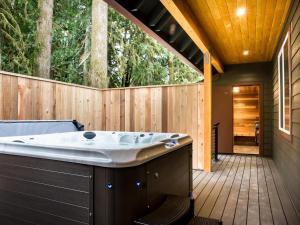 a jacuzzi tub sitting on a wooden deck at Swiss Marmot in Glacier +37 photos