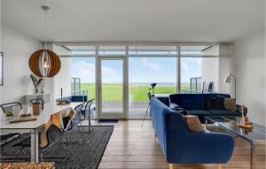 エーベルトフトにあるNice Apartment In Ebeltoft With 2 Bedrooms, Sauna And Wifiのリビングルーム(青いソファ、テーブル付)