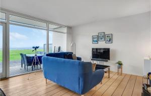 エーベルトフトにあるNice Apartment In Ebeltoft With 2 Bedrooms, Sauna And Wifiのリビングルーム(青いソファ、テレビ付)