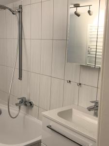 a white bathroom with a sink and a shower at Gemütlichkeit im Fachwerkhaus, 3 Schlafzimmer, Balkon, Parkplatz in Wolfhagen