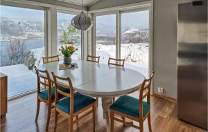 een keuken met een tafel en stoelen en een groot raam bij Gorgeous Home In Revsnes With Wifi in Refsnes