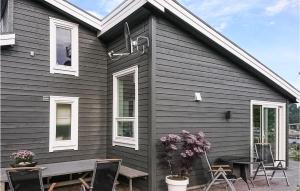 Refsnes的住宿－Gorgeous Home In Revsnes With Wifi，外面带桌椅的黑色房子