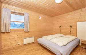 ein Schlafzimmer mit einem Bett in einem Holzzimmer in der Unterkunft 3 Bedroom Amazing Home In Fjrland in Fjærland