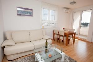 a living room with a white couch and a table at Apartment Marty in Zadar