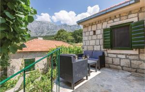 a house with a balcony with a table and chairs at Nice Home In Tucepi With 3 Bedrooms, Sauna And Wifi in Tučepi