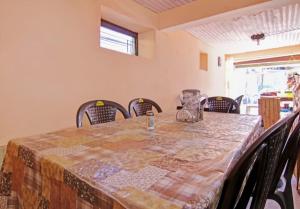 a dining room table with chairs and a table cloth at Deodar Homestay Dakbangla-kufri in Shimla