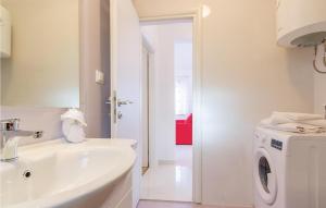 y baño blanco con lavabo y lavadora. en Lovely Home In Pula With Wifi en Pula